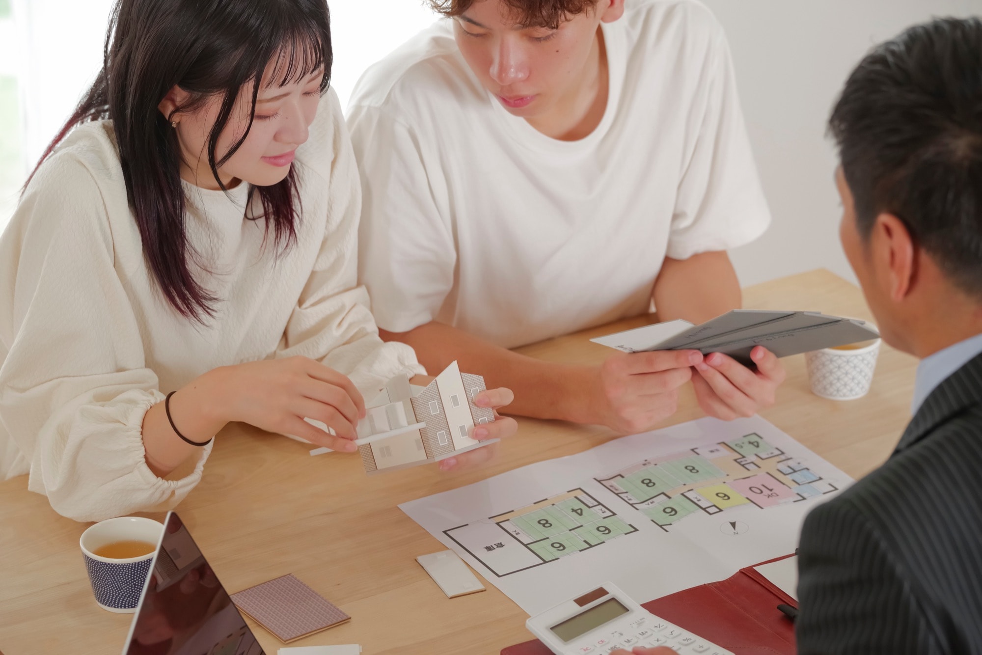 住宅会社スタッフに家づくりの相談をする若い夫婦